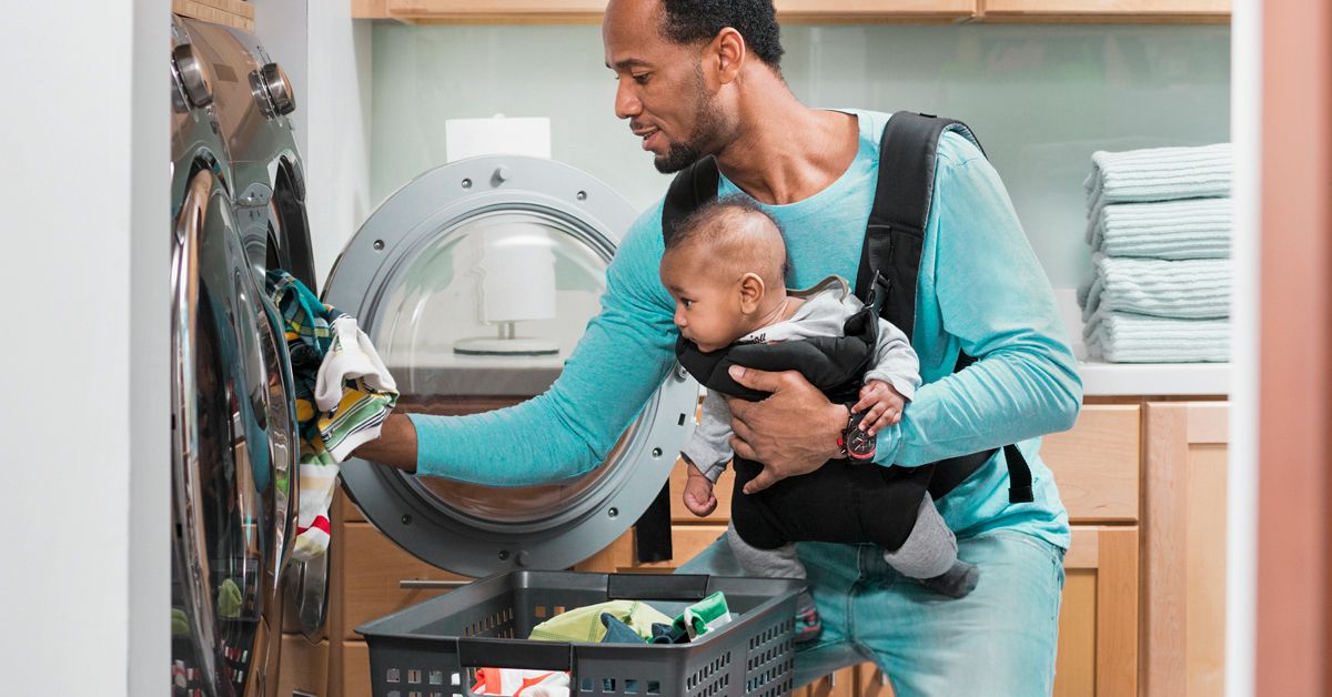 https://media.post.rvohealth.io/wp-content/uploads/2019/08/Black-father-with-son-in-baby-carrier-doing-laundry-1200x628-facebook.jpg