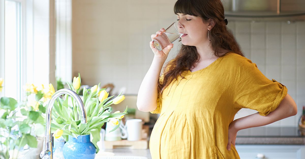 https://media.post.rvohealth.io/wp-content/uploads/2019/10/pregnant-woman-drinking-water-home-1200x628-facebook.jpg