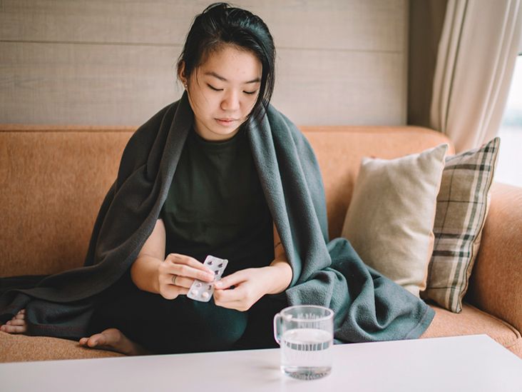 https://media.post.rvohealth.io/wp-content/uploads/2019/10/young-female-sitting-on-sofa-with-sickness-cover-with-blanket-taking-medicine-732x549-thumbnail.jpg
