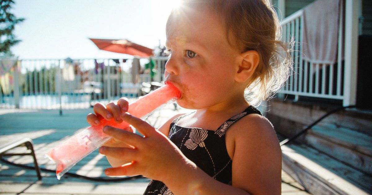 https://media.post.rvohealth.io/wp-content/uploads/2020/04/kid-toddler-red-dye-food-popsicle-pool-1200x628-facebook-1200x628.jpg