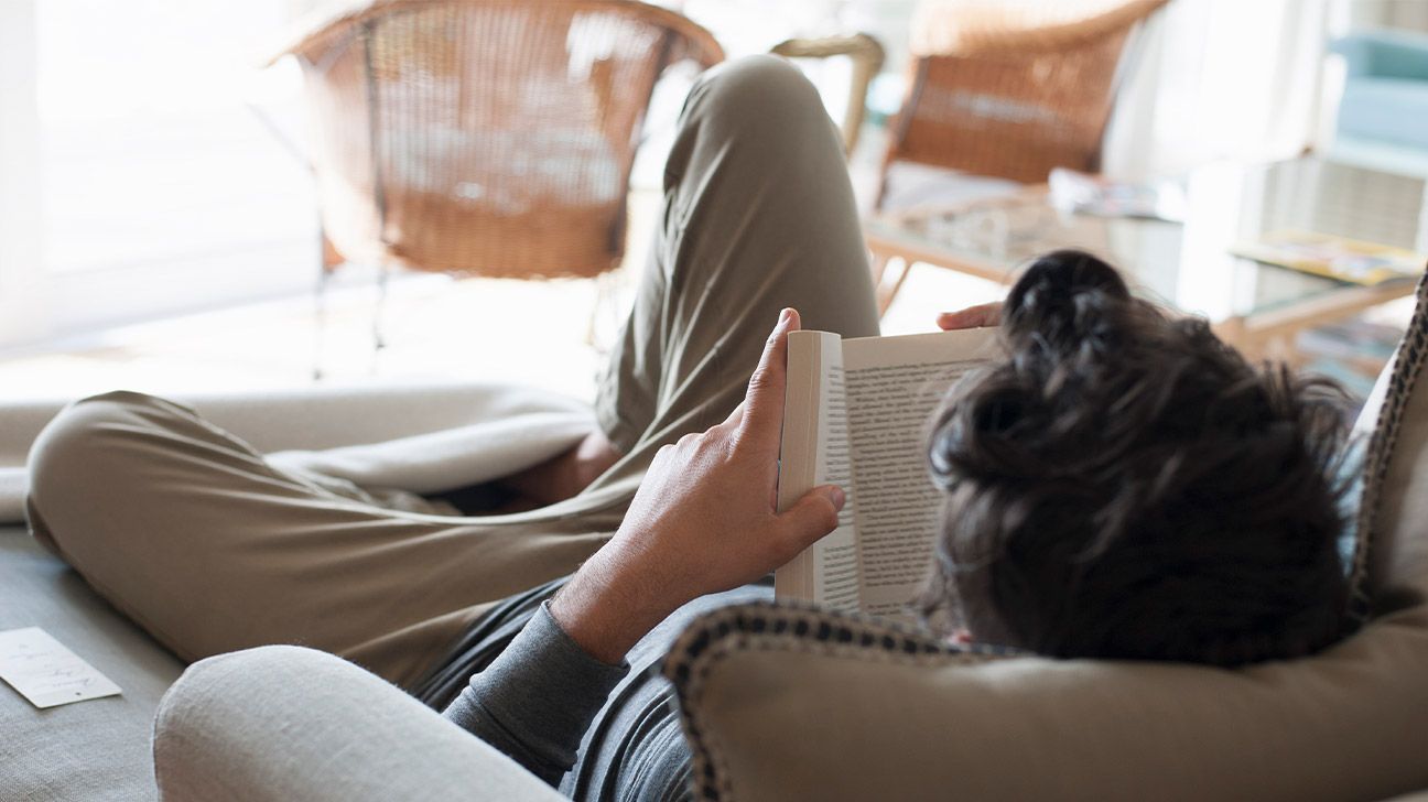 A man reads on the couch.
