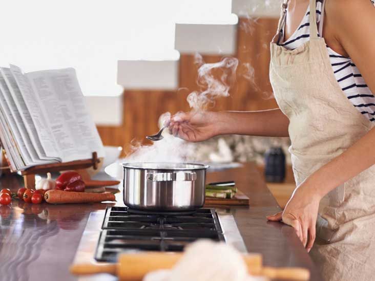 'a woman cooking in a kitchen'