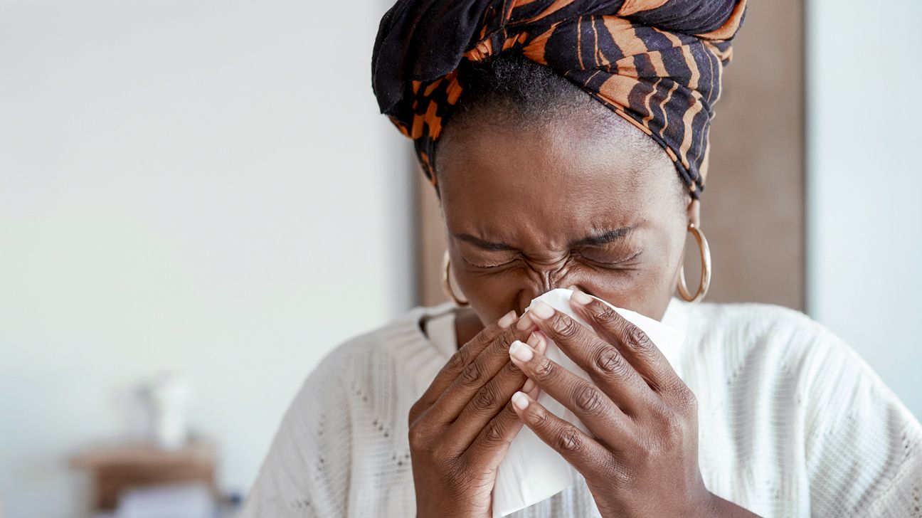 woman blowing her nose into a tissue