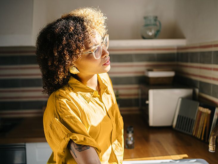 Uma pessoa idosa olhando pela janela, contemplando.