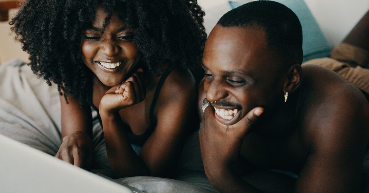 https://media.post.rvohealth.io/wp-content/uploads/2023/04/beautiful-black-couple-laughing-together-in-bed-1200x628-facebook-1200x628.jpg