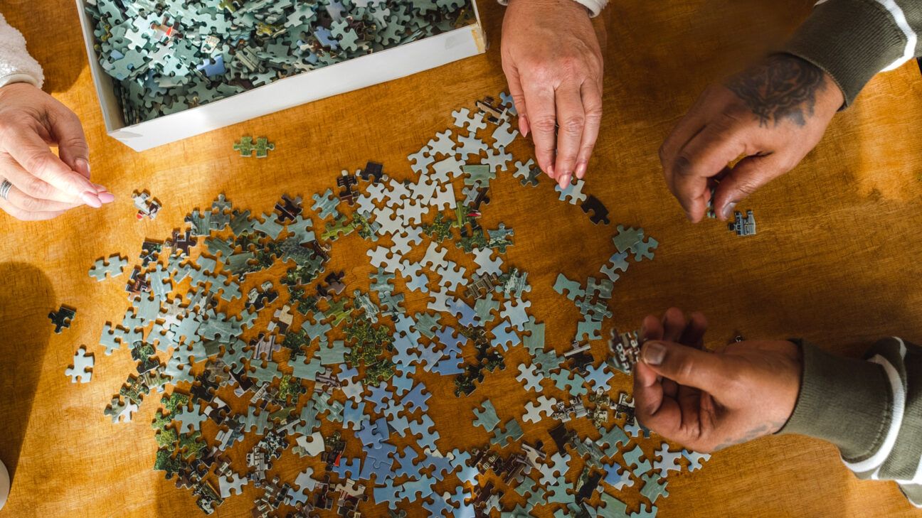 Due anziani affetti da demenza risolvono un puzzle per mantenere la mente e la coordinazione attive. 