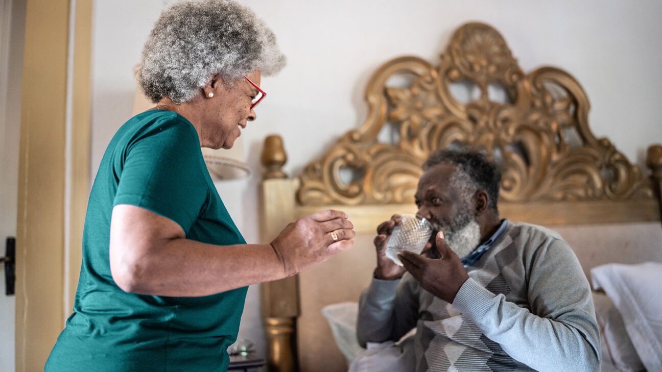 A man drinking water next to a smiling woman.