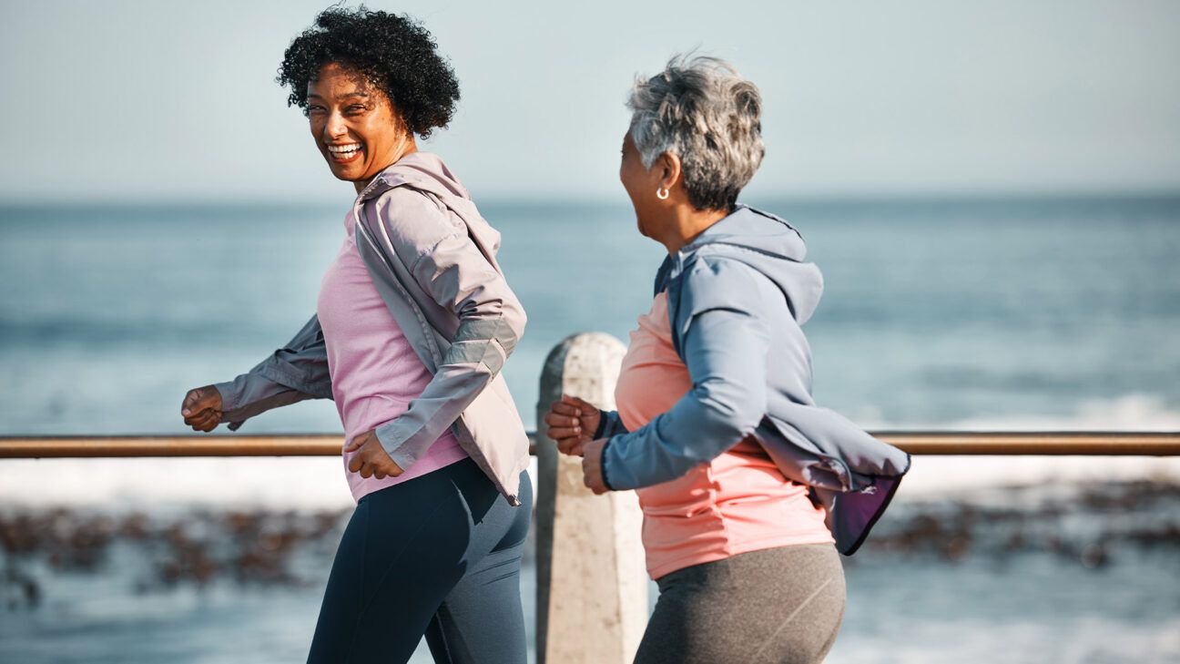 Two women go jogging outside.