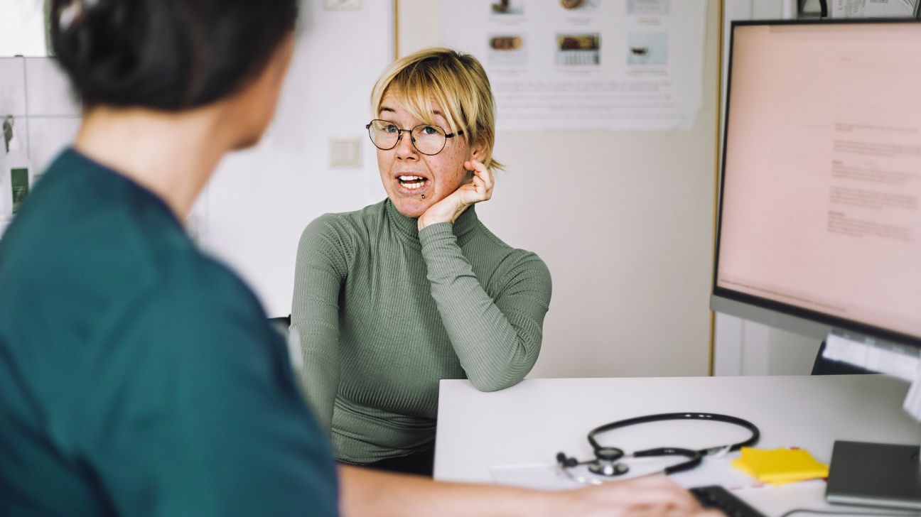 A woman speaks to a healthcare worker.