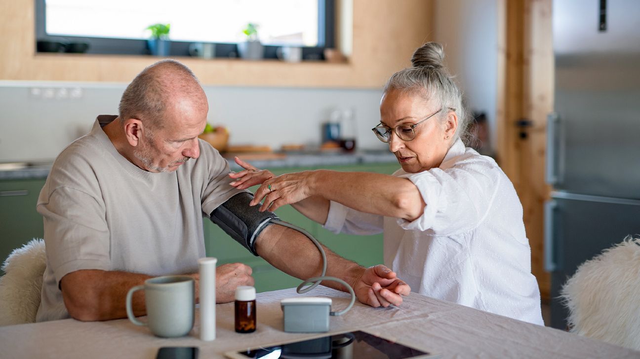 äldre person med renal hypertoni tar sitt blodtryck hemma
