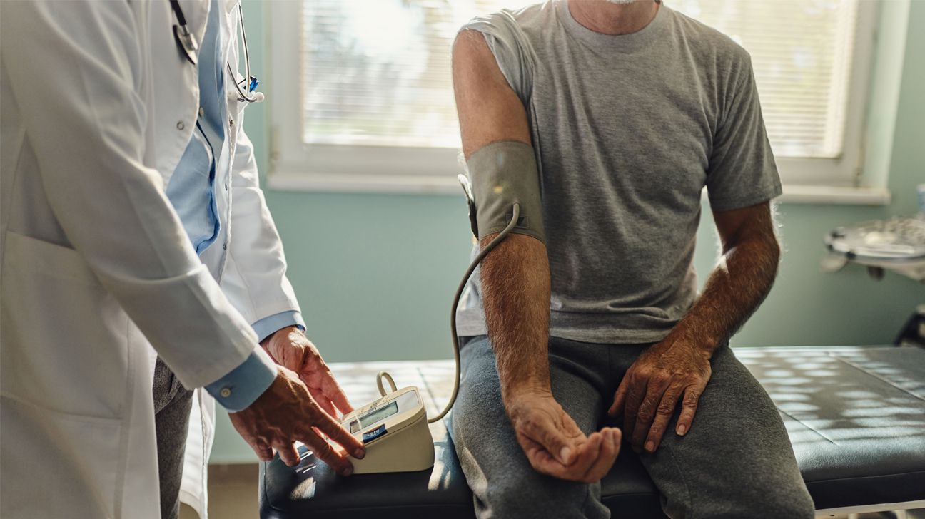 A doctors takes a man's blood pressure