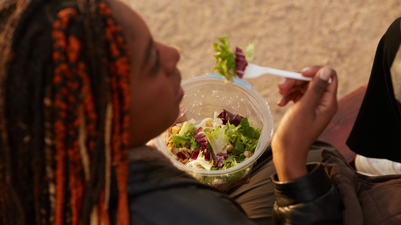 A woman eats a salad.