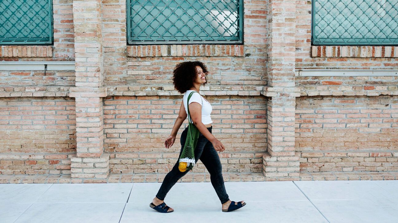 A woman walking on a sidewalk. 