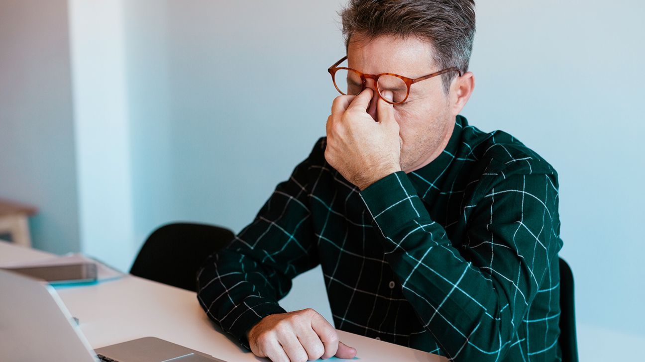 A man rubbing his eyes.