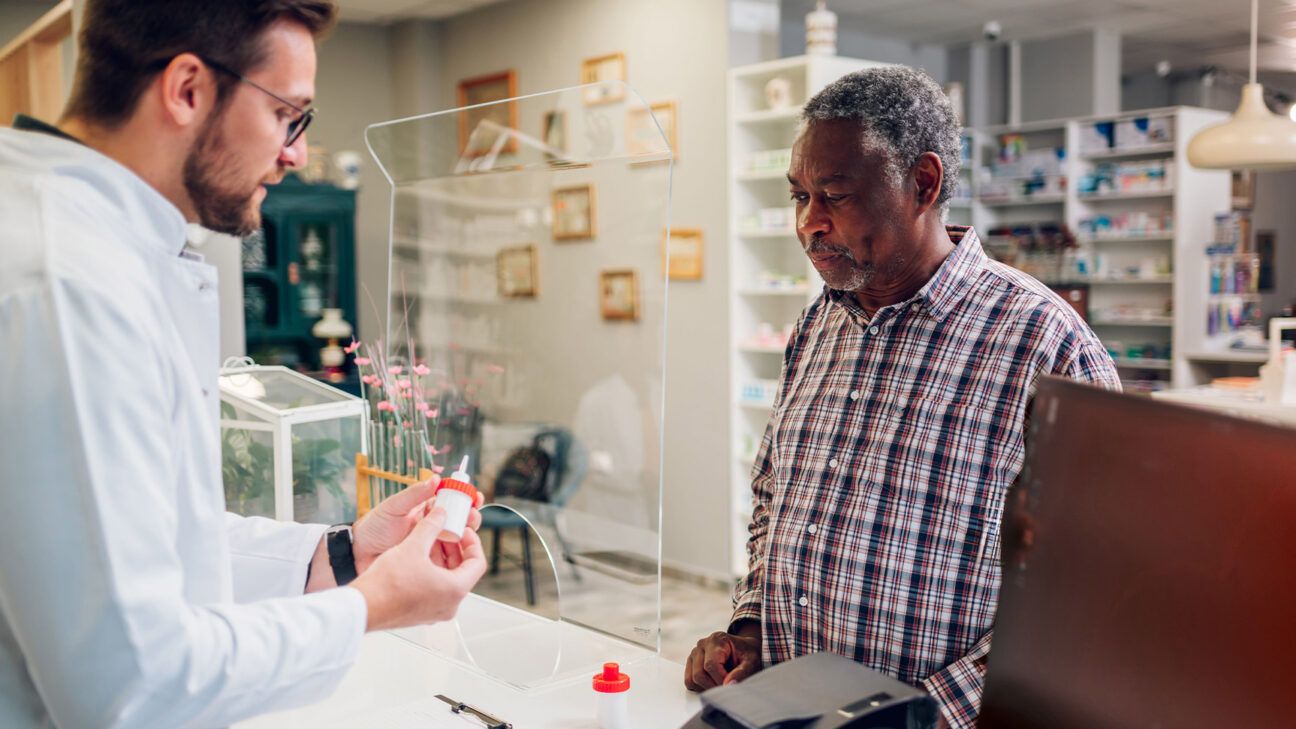 A man picking up prescription medication.
