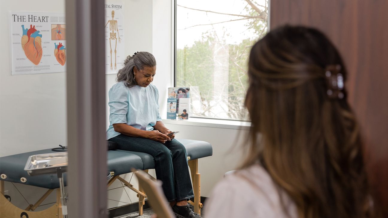 A woman waits for a healthcare worker in a physician's office.