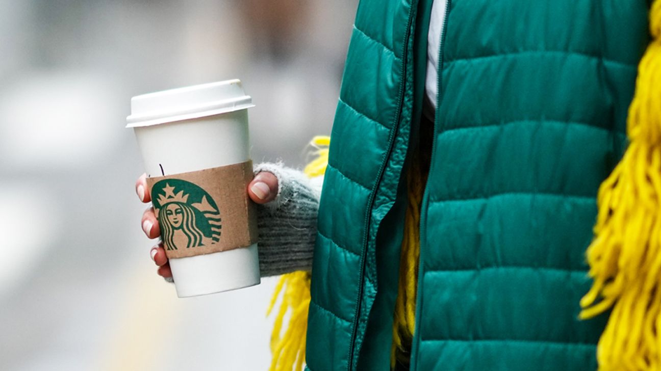 A person holding a Starbucks cup.