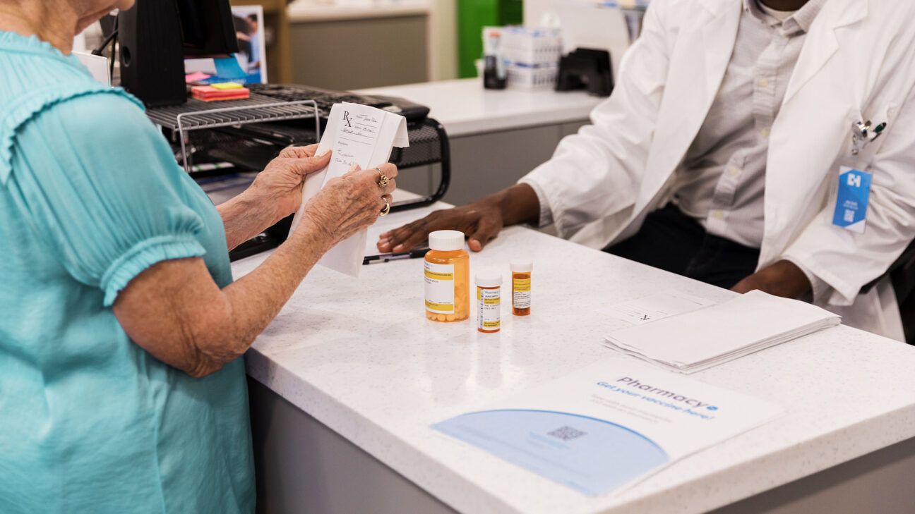 A person picking up prescription medication.