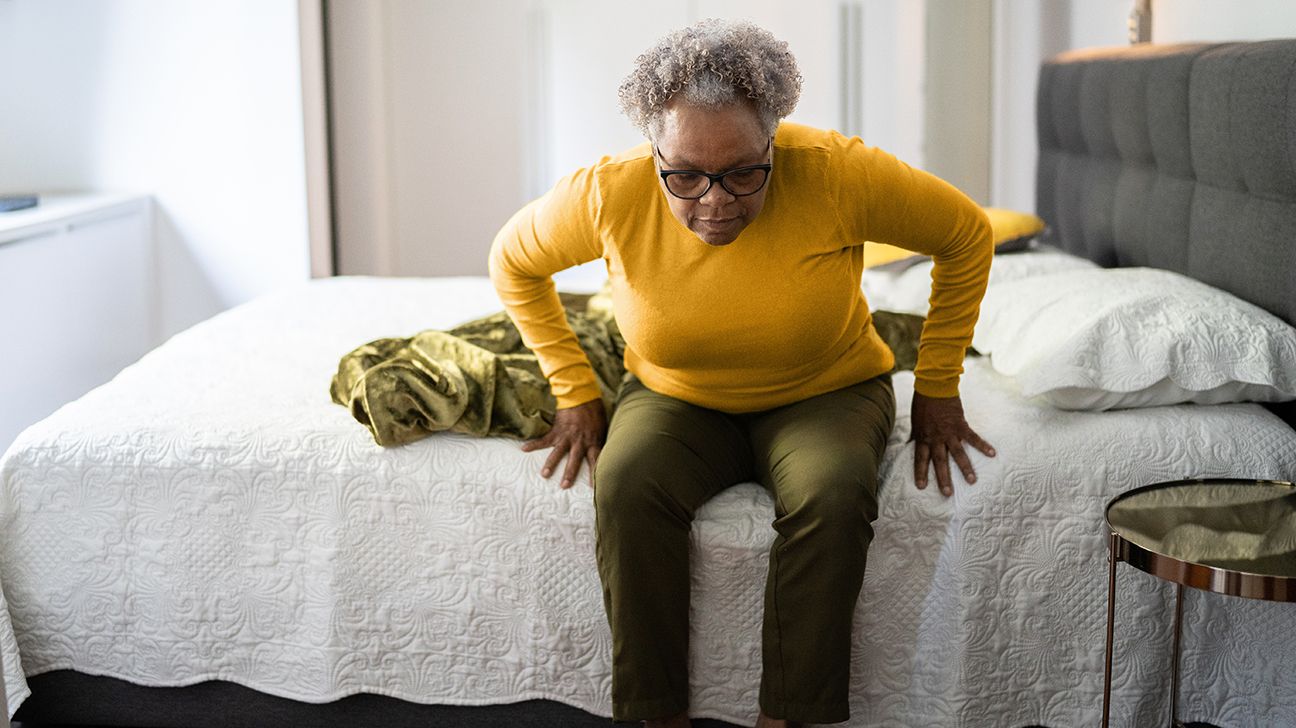 person having stand-up urinary urgency while standing up from a bed