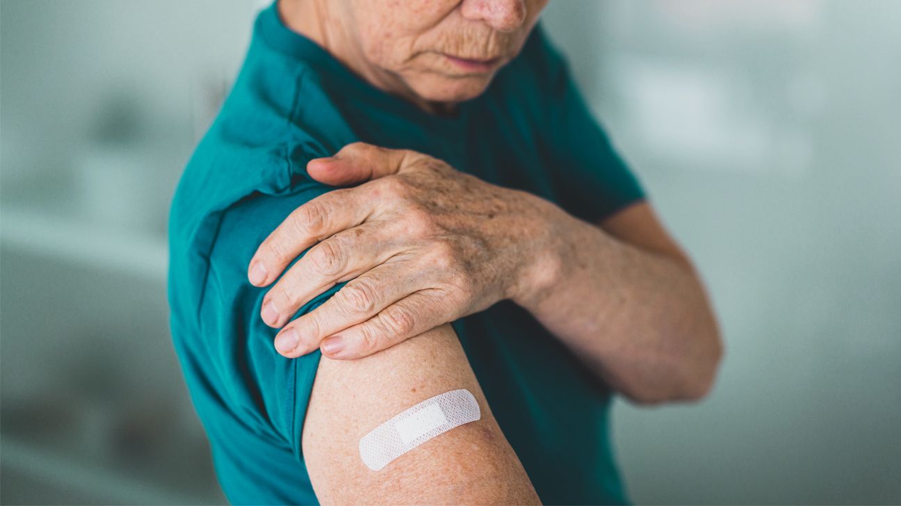 A person is seen with a bandaid on their arm.