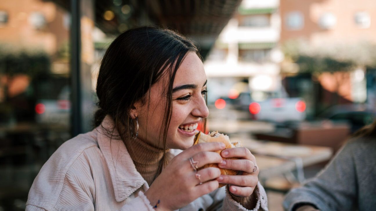 young person with pediatric scoliosis eating outside