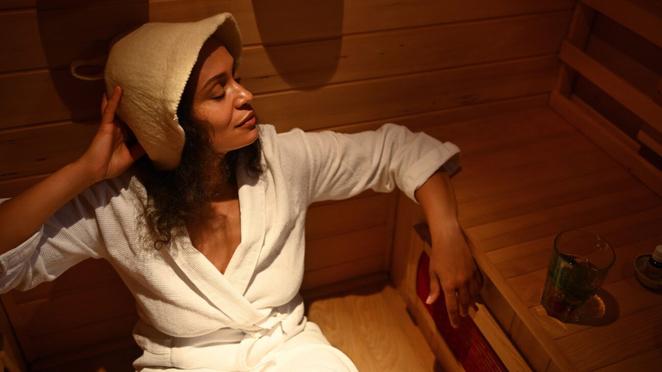 A white woman with eczema relaxes in an infrared sauna.