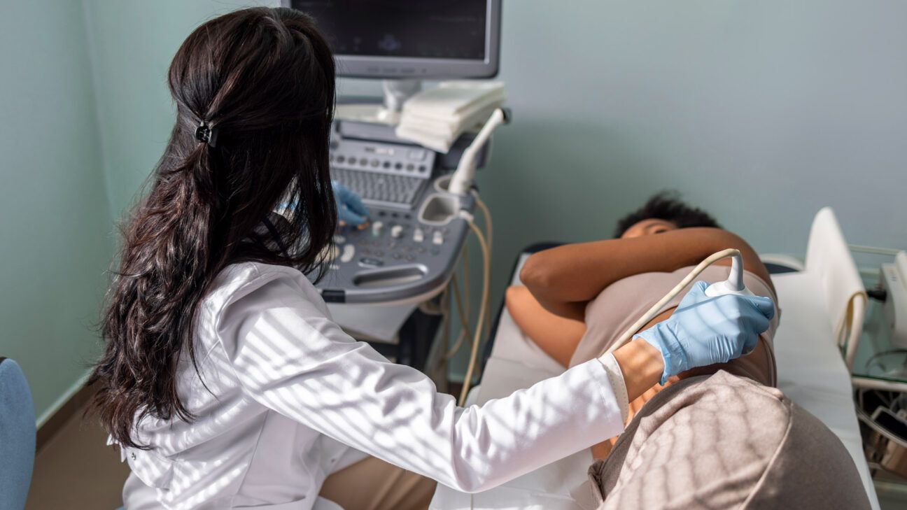 Medicinsk tekniker udfører en nyre-ultralyd på en kvinde