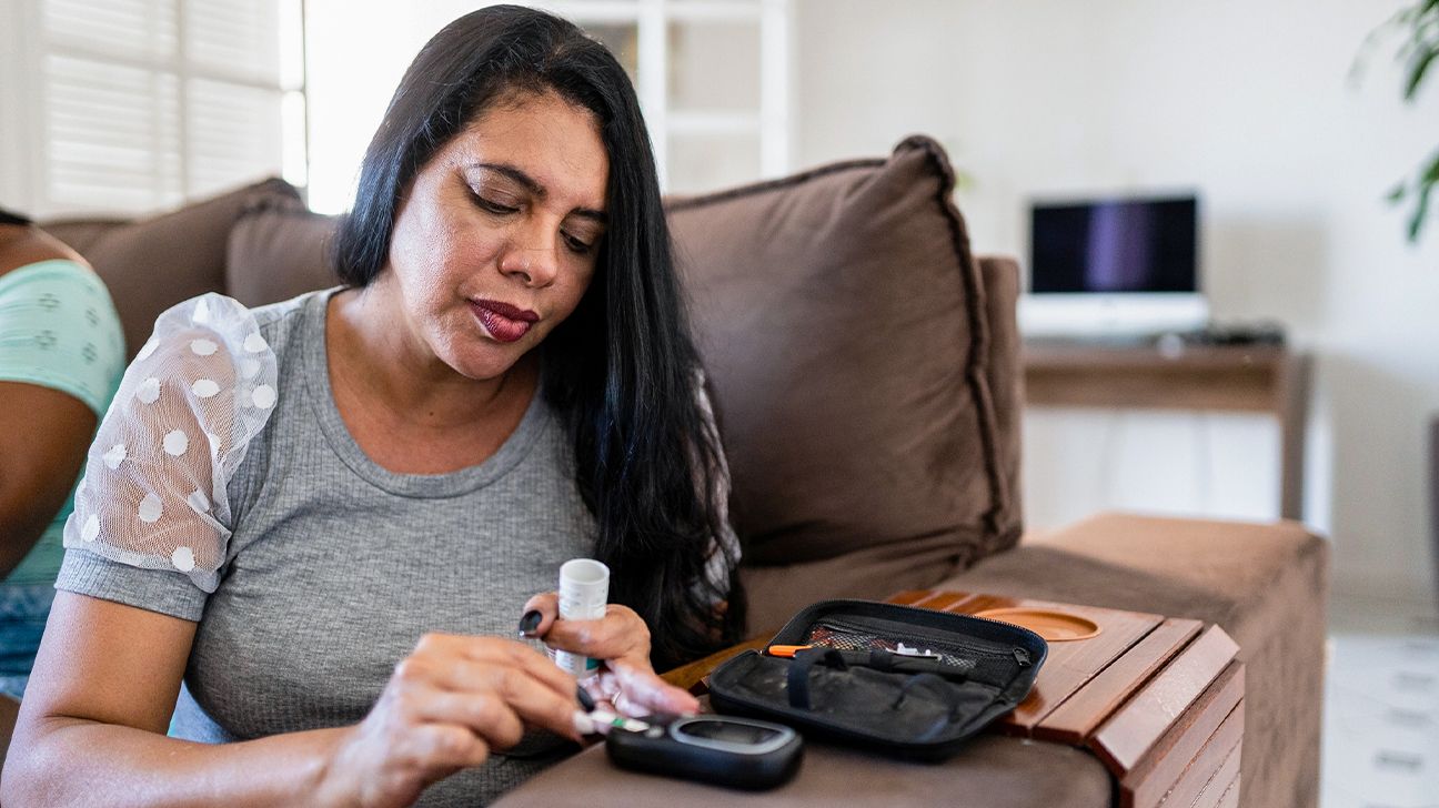 woman checks blood sugar at home