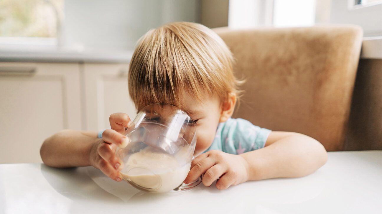 A toddler drinking milk.