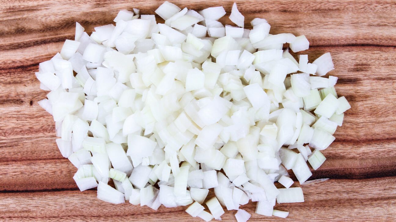 Diced onions seen on a cutting board.