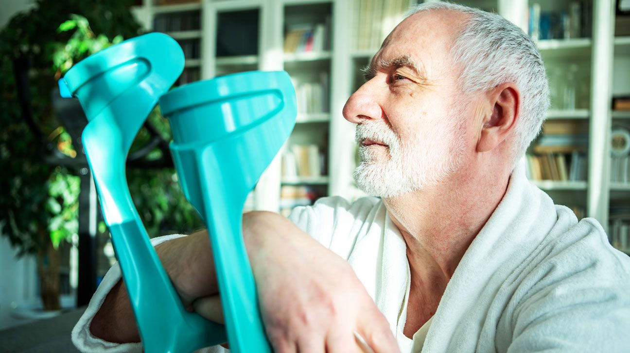 person with ALS holding blue crutches