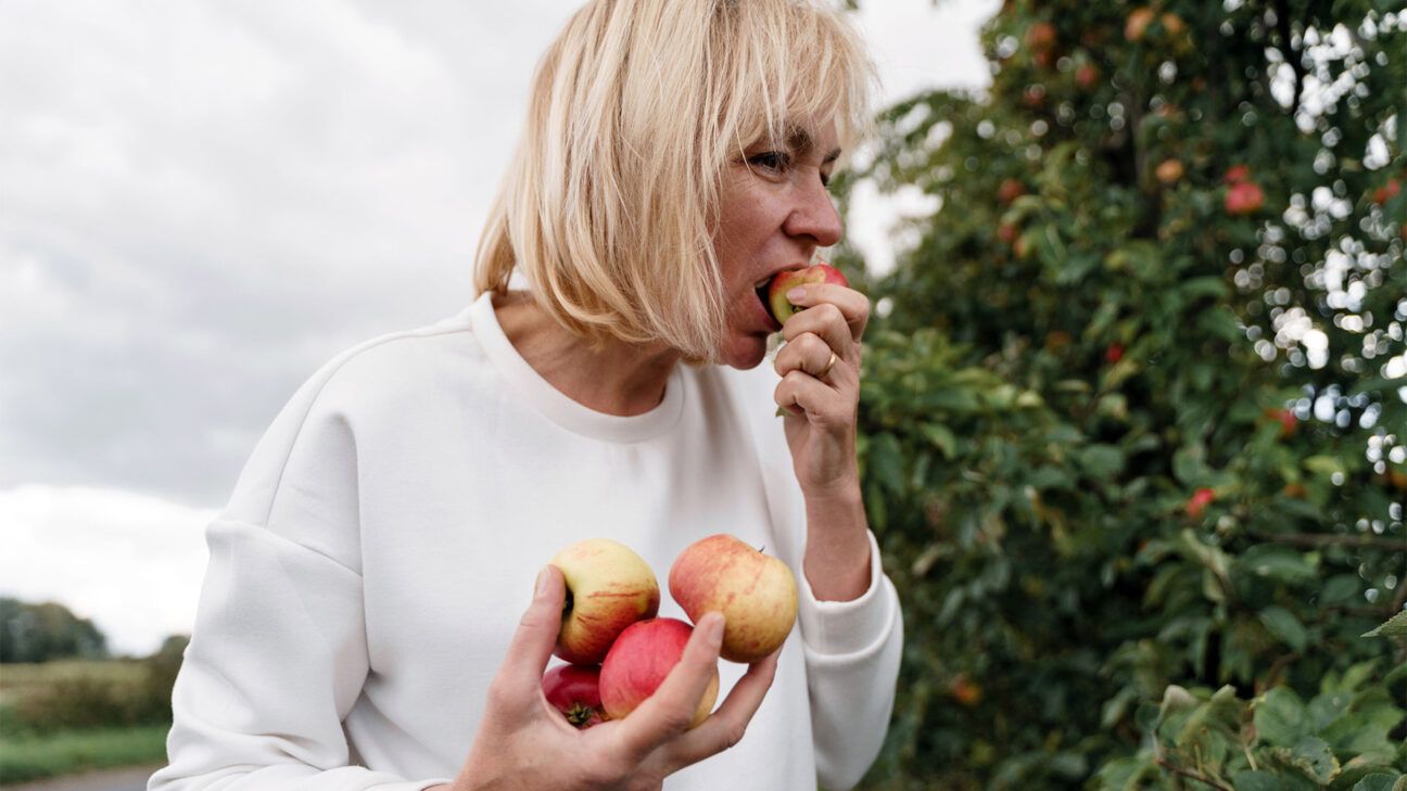 A woman eating apples.