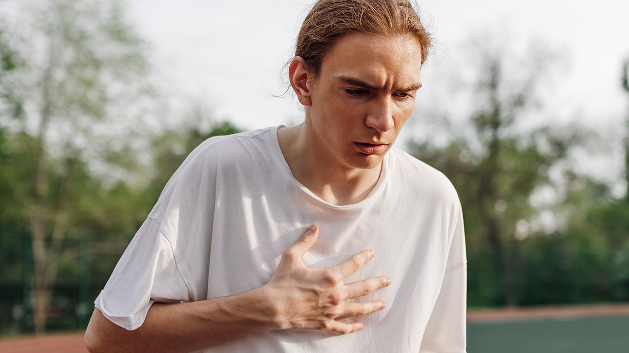person with hand on their chest having symptoms of congestive heart failure