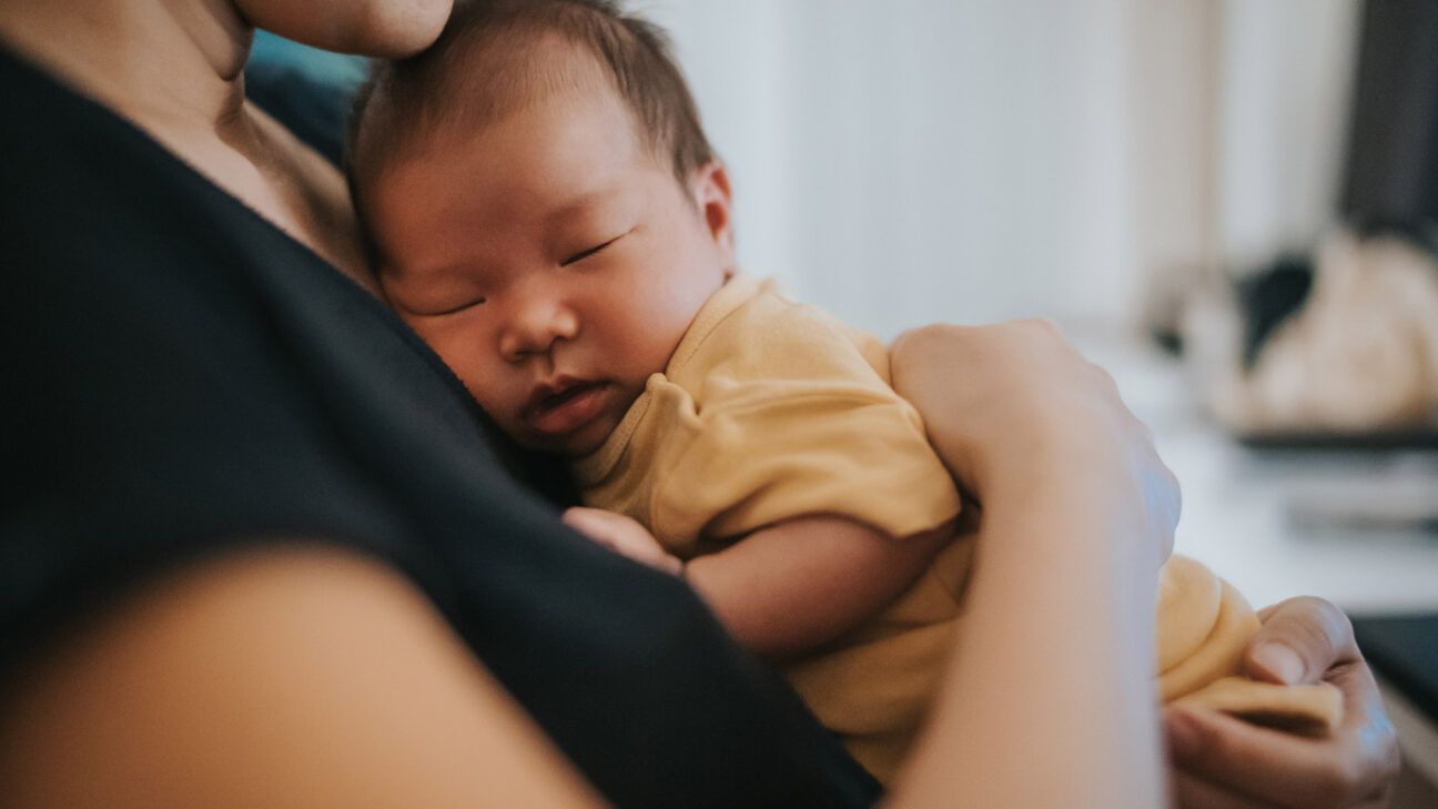 newborn with rhinitis being held