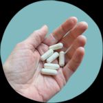 Thorne 50+ vitamins pills in hand