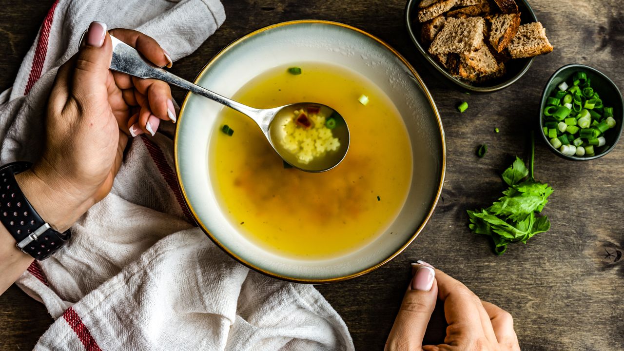 Handing scooping out of a bowl of soup with a spoon