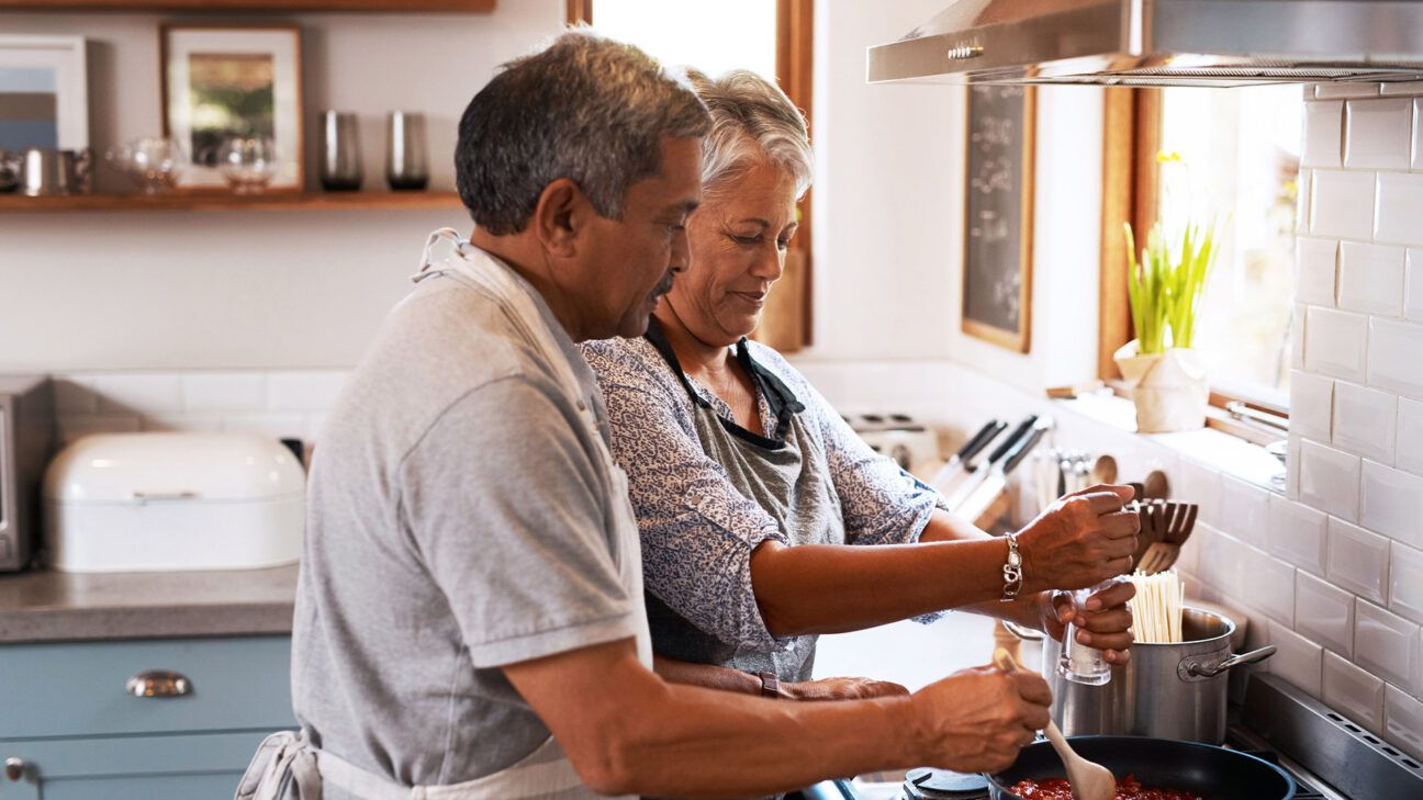 A couple cooking in a kitchen.