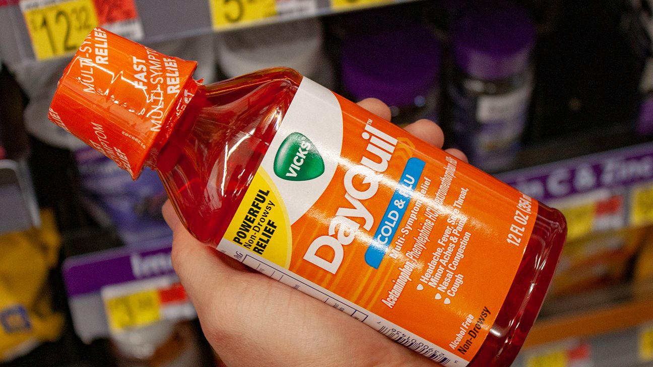 hand holding a bottle of DayQuil in a store