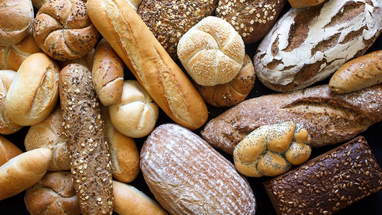 Many mixed breads and rolls shot from above.