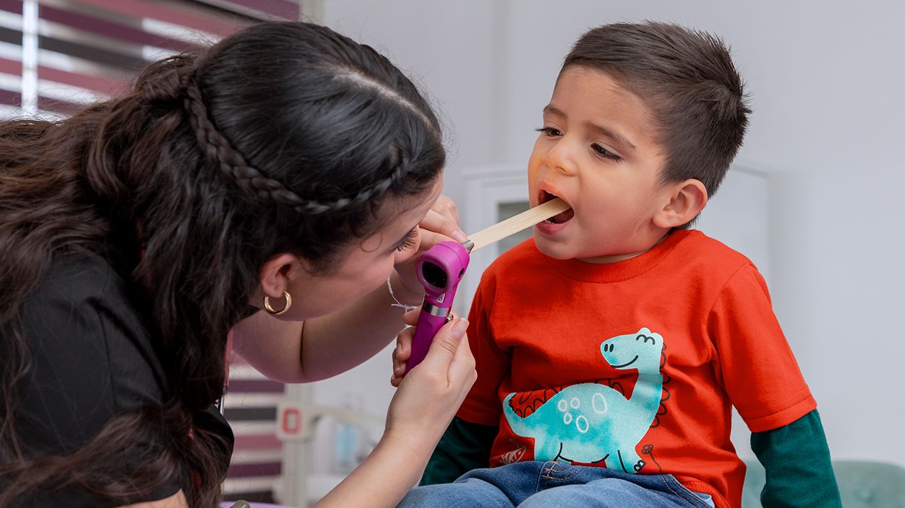 bambino piccolo che si sottopone ad un esame della bocca per verificare la presenza di cancro orale