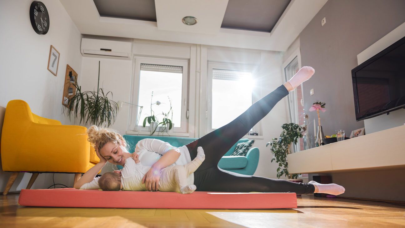New mother exercises on a mat with baby
