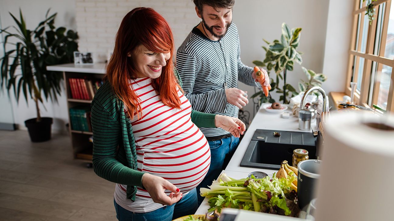 pregnant couple prepares food