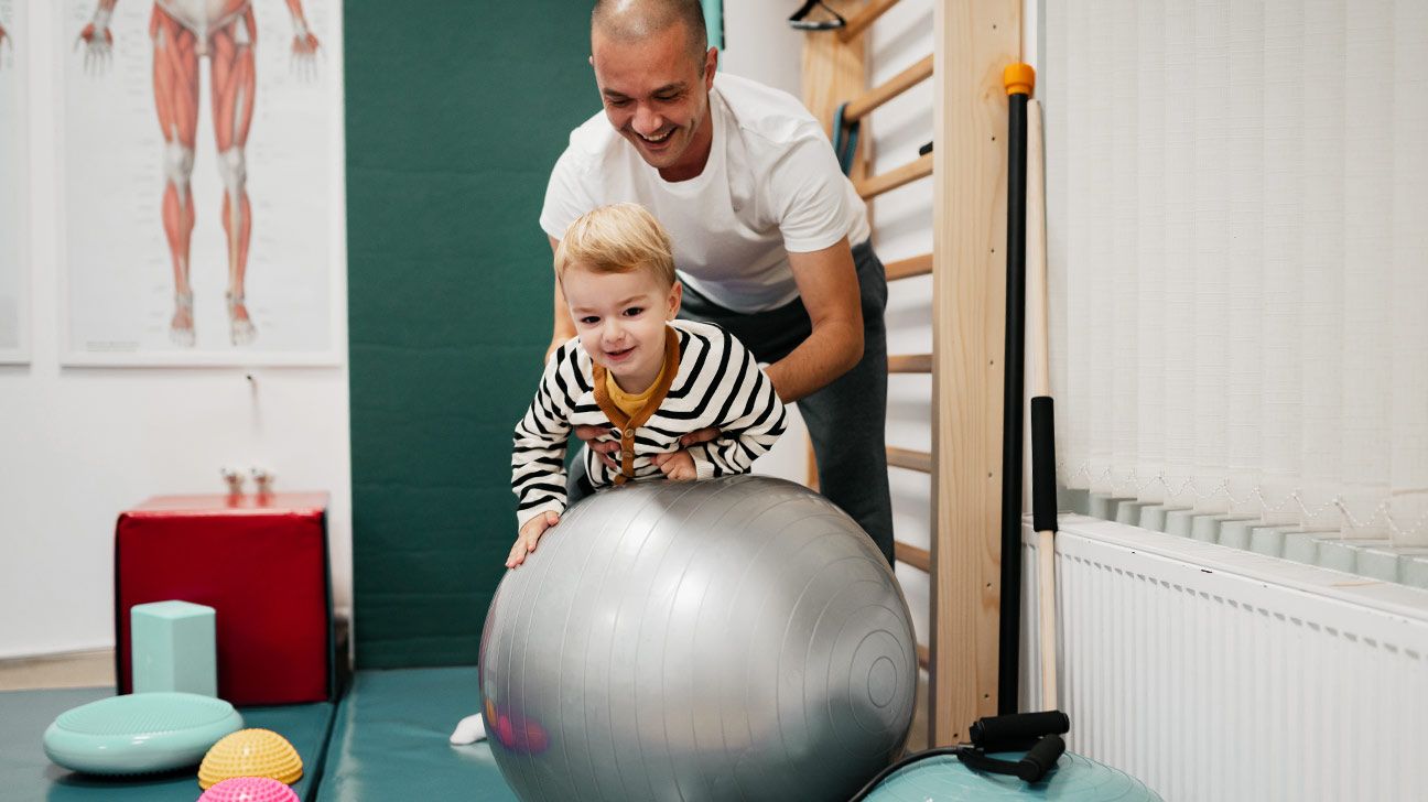 little boy with Duchenne muscular dystrophy having physical therapy