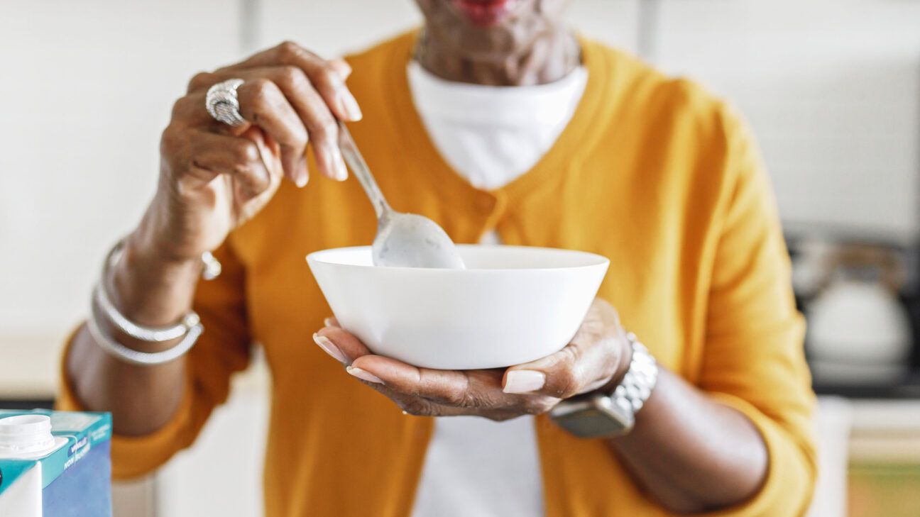 A woman eating a bowl of yogurt.
