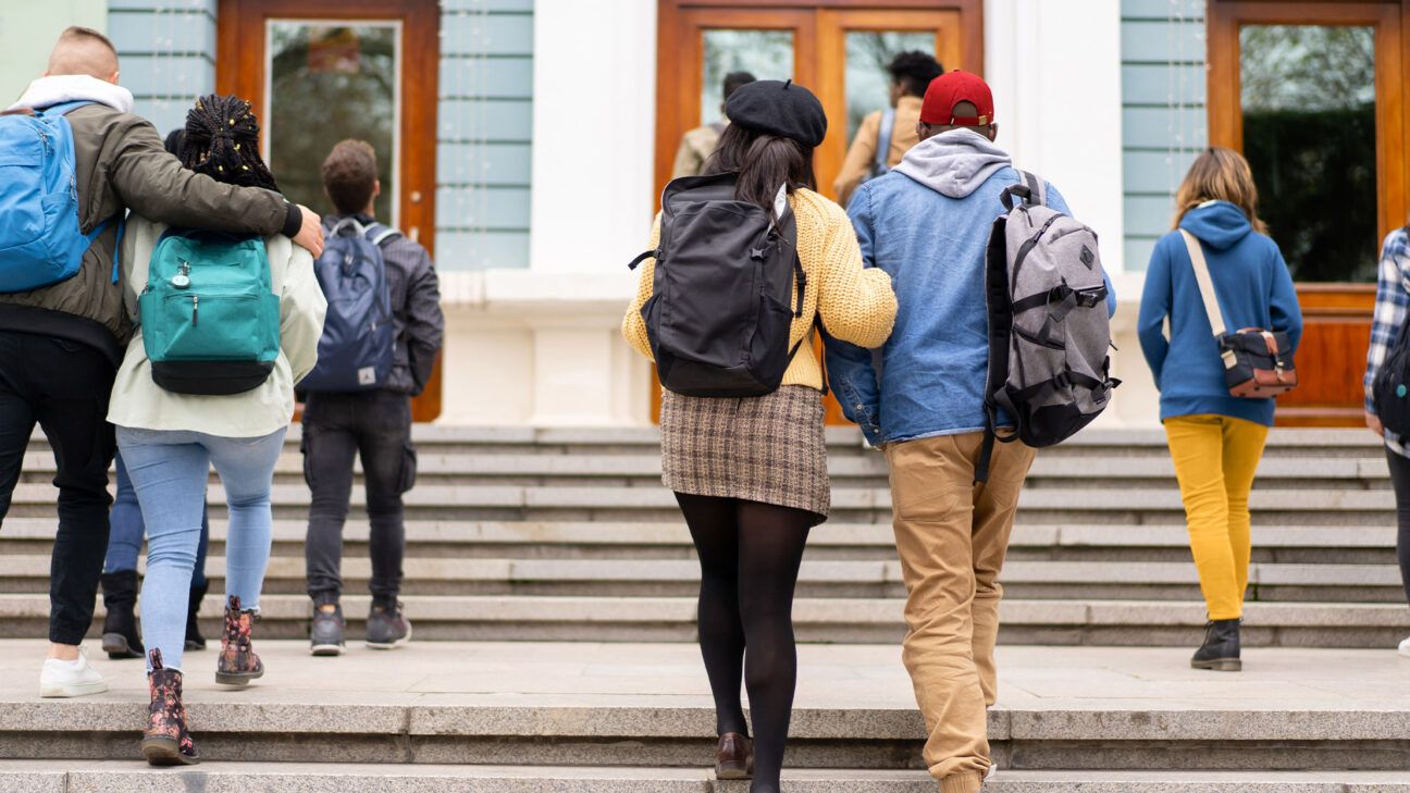 College students walk up the steps at their school