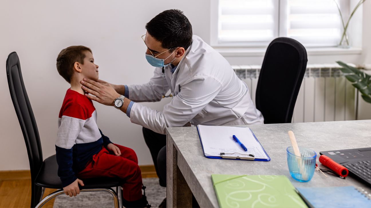 طبيب يفحص طفلاً مصابًا بسرطان الغدد الليمفاوية