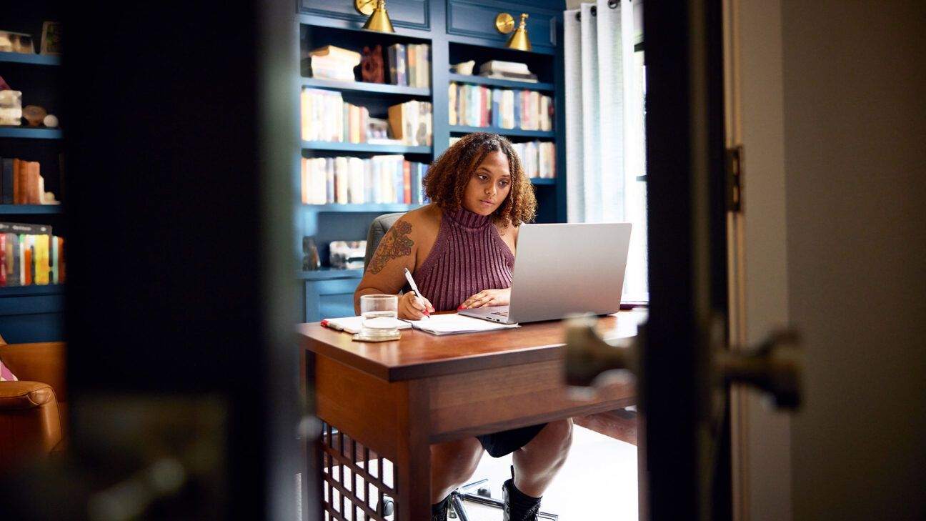 Woman sitting at a desk using a computer.