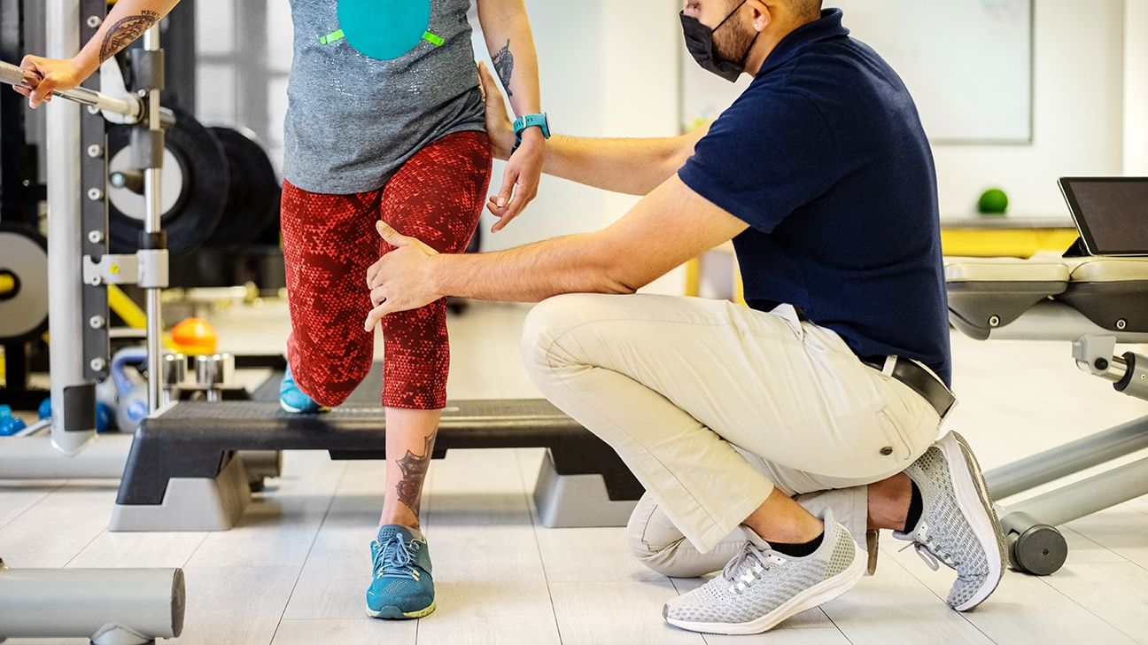 En fysioterapeut hjälper någon med cerebral pares genom sina stretchövningar.