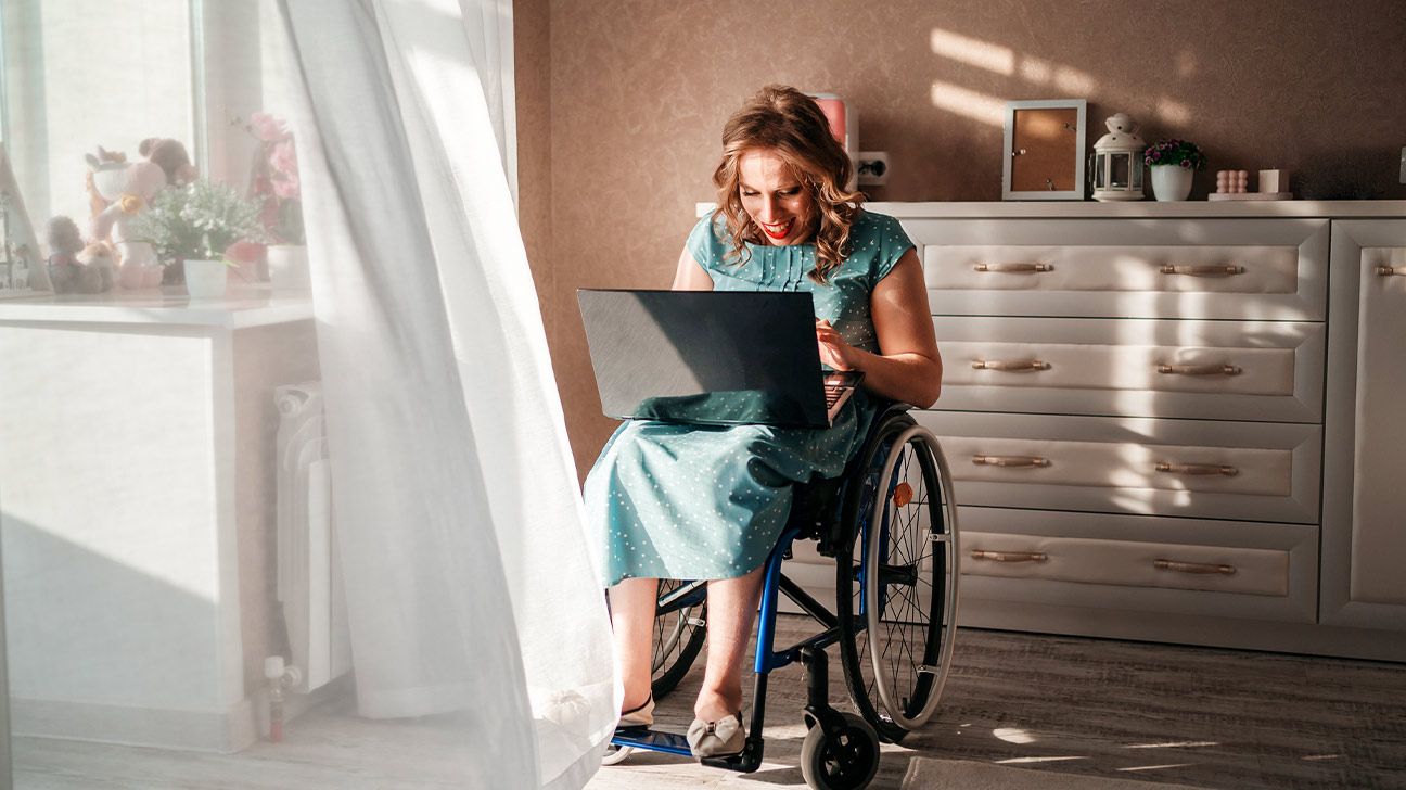Female working on her laptop seated in a wheelchair.