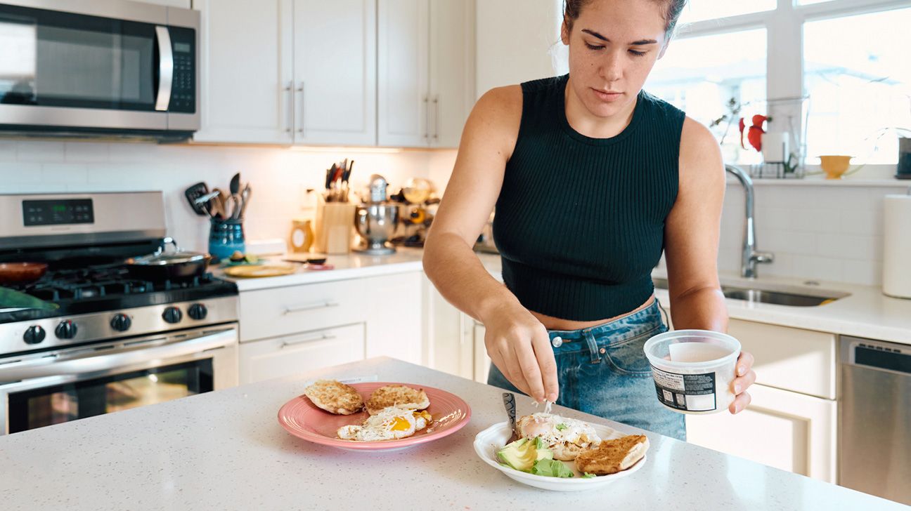 woman preparing avocado toast at an american kitchen